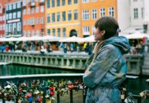 Woman standing near orange yellow and white buildings