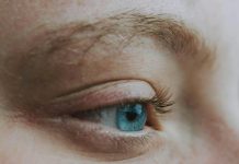 Crop unrecognizable dreamy woman with blue eye