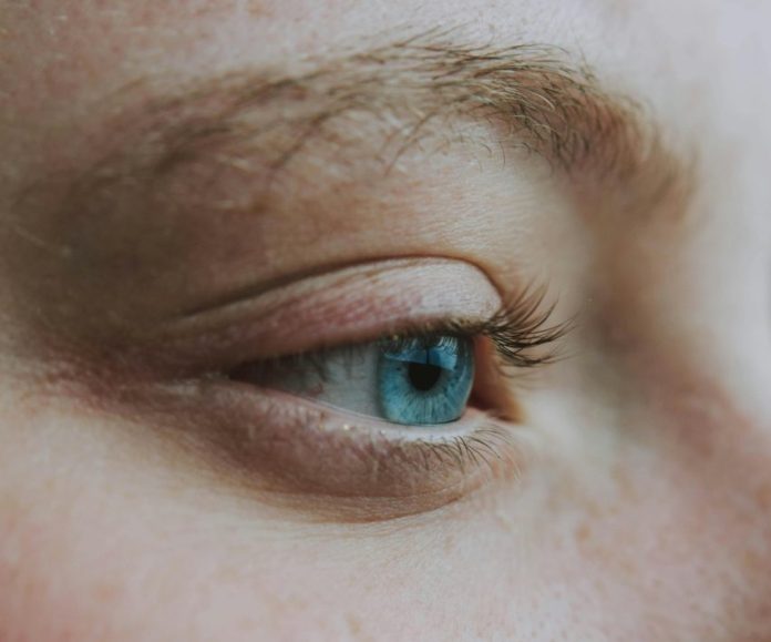 Crop unrecognizable dreamy woman with blue eye