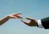Symbolic reach for connection against blue sky
