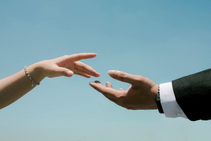 Symbolic reach for connection against blue sky
